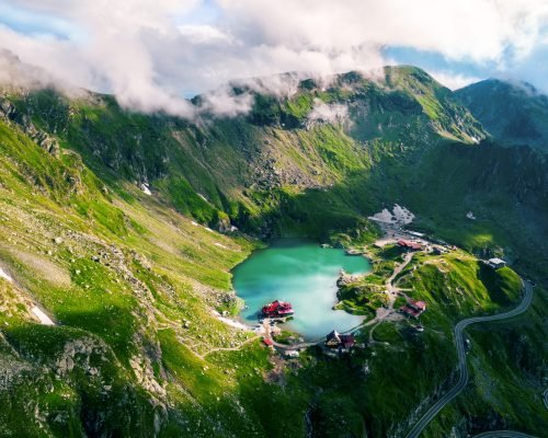 Aerial drone view of nature in Romania. Transfagarasan route in Carpathian mountains, Balea Lake resort and rocky slopes covered with greenery